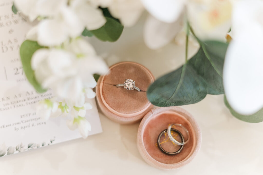 Bridal detail shot with mauve ring holder and white flowers