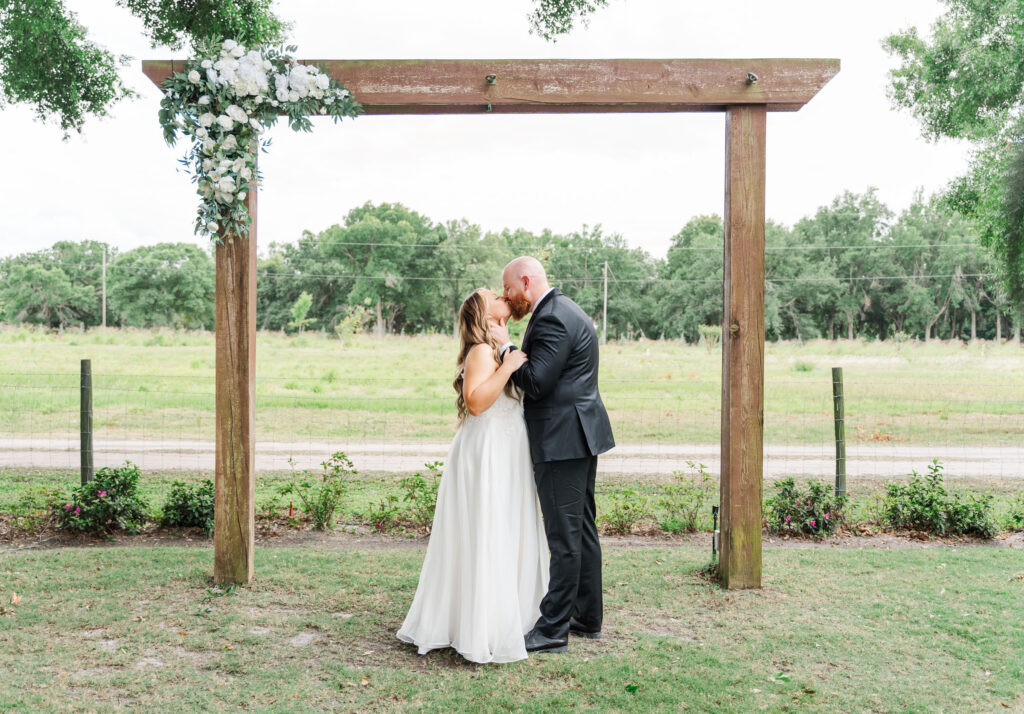 bride and groom kiss under alter