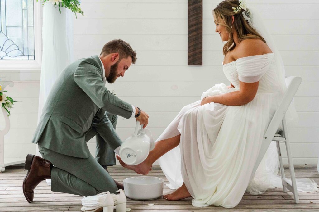 bride and groom at the alter washing each others feet 