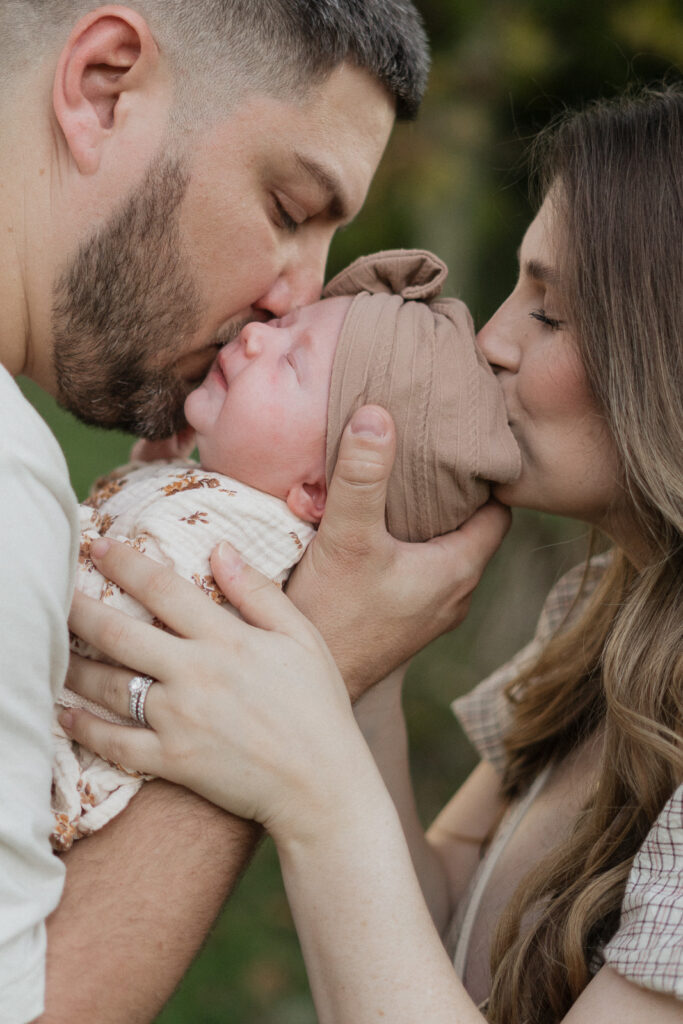 Lakeland family photographers parents kissing newborn.jpg